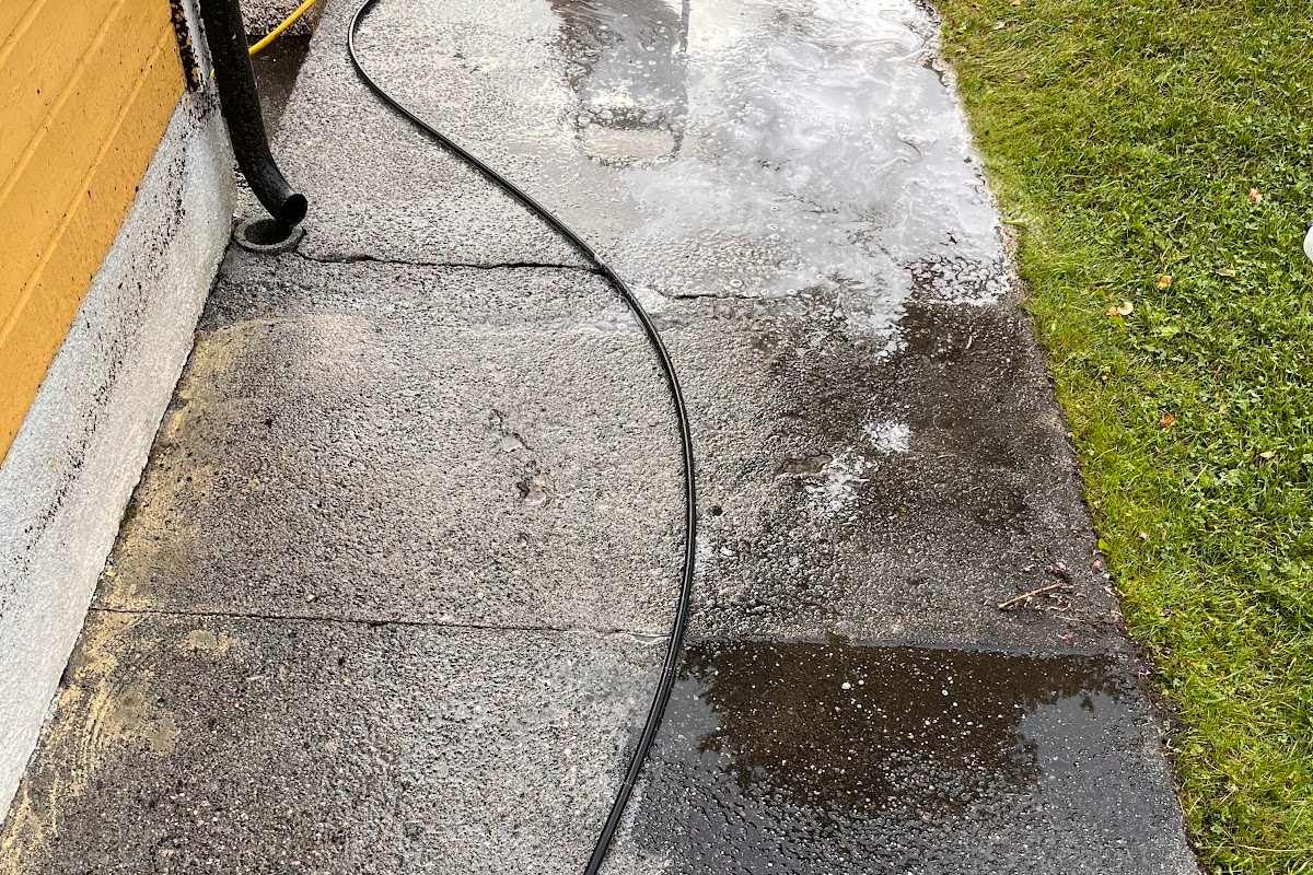 Høytrykkspyling av en betongvei ved bolig